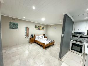 a bedroom with a bed in the middle of a room at Blade Flatlet 2 in Silver Sands