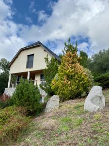 une maison sur une colline avec des rochers devant elle dans l'établissement Chalet Montagne, à Saint-Pastous