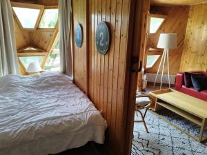 une chambre avec un lit dans une pièce aux murs en bois dans l'établissement Résidence Le Santel - 3 pièces · La Daille · Ski aux pieds MAE-1733, à Le Crêt