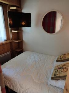 a small bedroom with a bed and a mirror at Résidence Pierre Et Vacances La Daille - appartement proche pistes et commerces MAE-1803 in Le Crêt