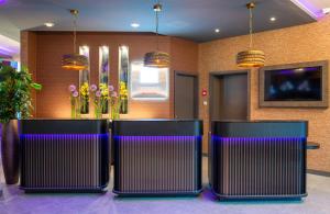 Una fila de sillas en un vestíbulo con iluminación violeta. en Leonardo Royal Hotel Nürnberg, en Núremberg