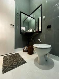 a bathroom with a toilet and a mirror at Casa No Centro de Caldas Novas in Caldas Novas