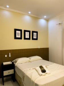 a bedroom with a bed with three pictures on the wall at Casa No Centro de Caldas Novas in Caldas Novas
