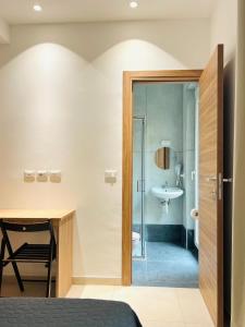 una camera da letto con scrivania e un bagno con lavandino di Hotel Brivio a Milano Altre 62 foto