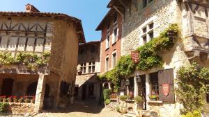 an alley in an old building with flowers and plants at Le Chalet des Iris in Saint-Maurice-de-Gourdans