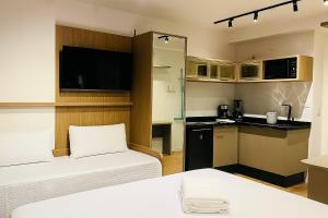 a hotel room with two beds and a kitchen at IBZ1308 - Studio C Sacada Pscina Jacuzzi Academia in Curitiba