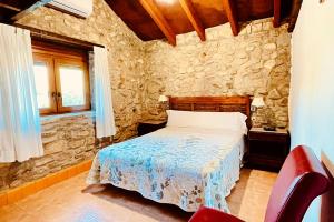 a bedroom with a bed and a stone wall at Alojamiento Turístico Nacarum in El Palmar +126 photos