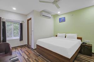 a bedroom with a large white bed and a window at Hotel O SKS Grand Luxury Rooms near by Nagole x Road and Bandlaguda in Upal
