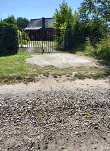 ein Tor vor einem Hof mit einem Haus in der Unterkunft Przystań Natury - Drewniany Dom Wakacyjny in Domysłów + 48 Fotos