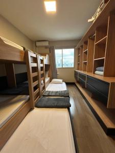 a dorm room with bunk beds and a window at Edifício Frente Mar Apto lateral in Balneário Camboriú +97 photos