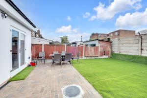 un pequeño patio trasero con césped verde en 4 Bed - Sleeps 8 - Free Parking - Garden, en Dagenham