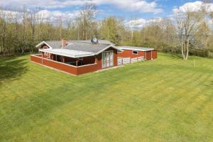 a small red house on a large grass field at LF14221-Roslev-Astrup-Vig-81 in Roslev