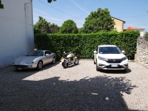 two cars and a motorcycle parked in a driveway at B&B LA CORTE SANTA MARIA in Negrar