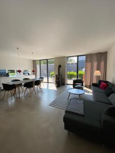 a living room with a couch and a table at Haus Charly Exklusives Architektenhaus Holzbauweise Fehmarn, strandnah in Fehmarn