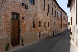 an alley with a brick building with a wooden door at Dé Corner Rooms and Suites in Soncino