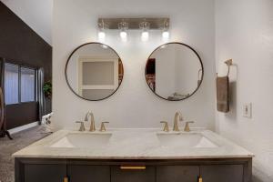 a bathroom with two sinks and two mirrors at Brick Home Hot Tub BBQ Fire Pit Dogs Ok King Bed in Gilbert +26 photos