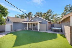 a house with a backyard with a green lawn at Brick Home Hot Tub BBQ Fire Pit Dogs Ok King Bed in Gilbert
