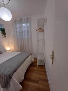 a bedroom with a white bed and a shelf at El patio in La Laguna