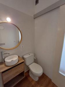 a bathroom with a toilet and a sink and a mirror at El patio in La Laguna +16 photos
