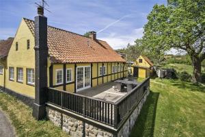 a yellow house with a deck in front of it at 5525-Svaneke-Bolshavn-19 in Svaneke