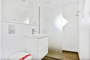 a white bathroom with a sink and a toilet at 5525-Svaneke-Bolshavn-19 in Svaneke