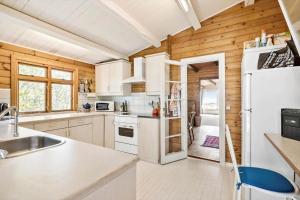 a kitchen with white appliances and wooden walls at 6685-Allinge-Tejnvej-24 in Allinge +14 photos