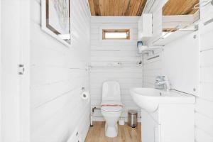 a white bathroom with a toilet and a sink at 6685-Allinge-Tejnvej-24 in Allinge