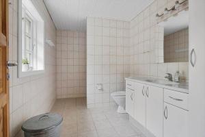 a white bathroom with a toilet and a sink at 3671-Nexo-Dunhammervej-3 in Neksø