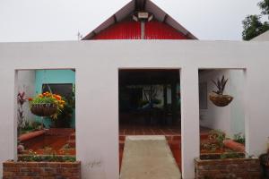 a white building with two potted plants on it at La Casona in Arauca +11 photos