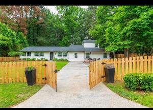 a house with a wooden fence and a driveway at Pendo in West Hampton