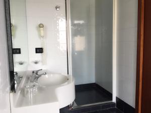 y baño blanco con lavabo y ducha. en Hotel Giardino degli Aranci, en Frattamaggiore