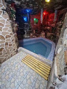 Una piscina con un banco al lado de una casa. en Cabana Micutu, en Sebeş