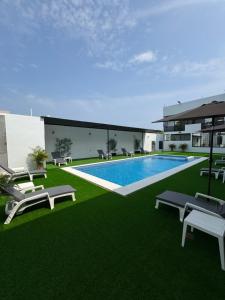 a building with a swimming pool and green grass at Houzze Plety in Brisas de Zicatela