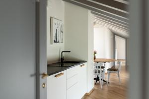 a kitchen with white cabinets and a table in a room at Dé Corner Rooms and Suites in Soncino +24 photos