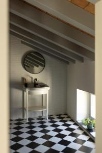 a room with a table and a mirror and a checkered floor at Dé Corner Rooms and Suites in Soncino