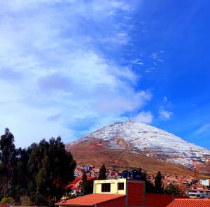 a snow covered mountain in the sky over a city at Casa MariaVictoria Hostal in Potosí +1 photo