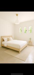 a white bedroom with a large bed and windows at Prestigious 5-star garden villa in Mougins