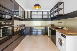 a large kitchen with a washer and dryer at Prestigious 5-star garden villa in Mougins