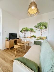 ein Wohnzimmer mit Couch und Flachbildfernseher in der Unterkunft La Pinède, Proche gare, Centre ville, Netflix in Bourgoin
