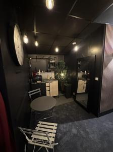 a room with a table and two chairs and a clock at Cocon Jacuzzi et cinéma 4K B in Bordeaux