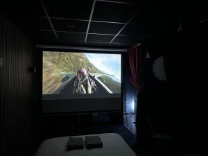 a tv in a dark room with a video game on it at Cocon Jacuzzi et cinéma 4K B in Bordeaux