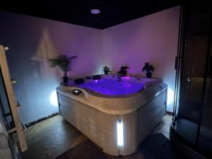 a purple bathroom with a tub with purple lighting at Cocon Jacuzzi et cinéma 4K B in Bordeaux