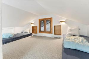 Un dormitorio con dos camas y una ventana. en 5555-Svaneke-Askelundsvej-12, en Svaneke