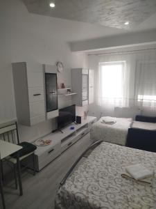 a bedroom with two beds and a tv and a table at Vea in Banja Koviljača