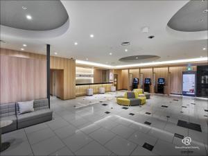 a lobby with couches and chairs in a building at Daiwa Roynet Utsunomiya in Utsunomiya