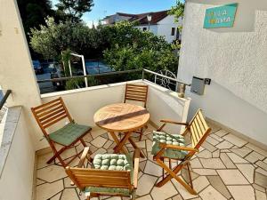 a patio with three chairs and a table on a balcony at Peaceful Villa Nana Brač in Milna