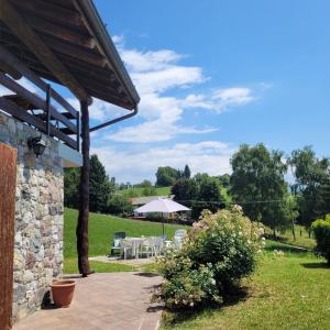 a patio with a table and chairs in a yard at Cinque Abeti Agrialloggio Mountain Lake Iseo Hospitality in Bossico