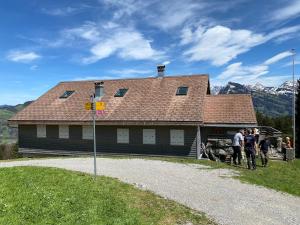 a group of people standing in front of a building at Modernes Skihaus auf der Wolzenalp 33Betten in Nesslau