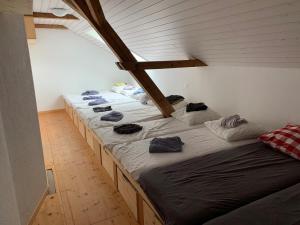 a row of beds in a room with a attic at Modernes Skihaus auf der Wolzenalp 33Betten in Nesslau