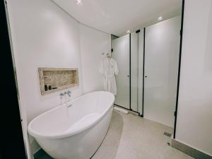 ein weißes Badezimmer mit Badewanne und Bademantel in der Unterkunft ArtHotel Transamerica Collection in Porto Alegre